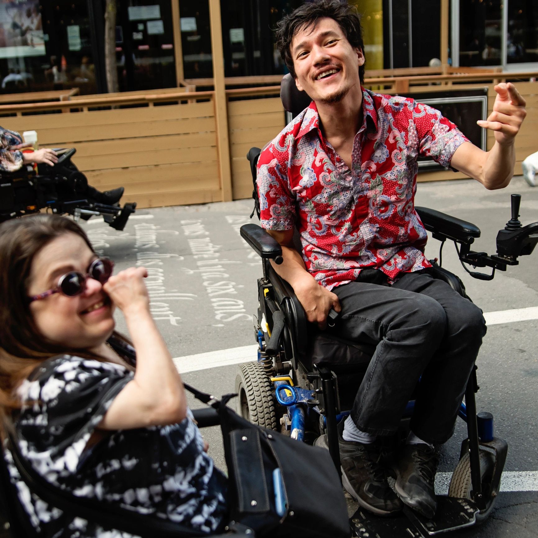 Two friends using wheelchairs meeting outdoors
